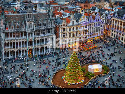 Vista sopraelevata della Grand Place di Bruxelles, Belgio, decorata per il periodo natalizio con un albero e case illuminate Foto Stock