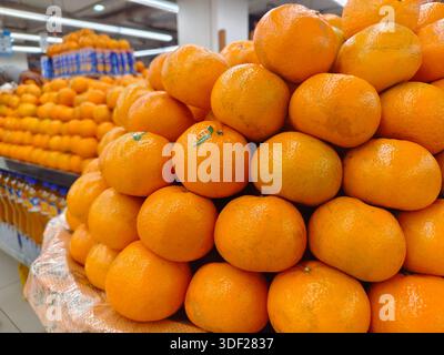 Karachi, Pakistan - 14 dicembre 2025: Frutta sul carrello per la vendita. Mazzo di mandarini freschi sul mercato. Primo piano Foto Stock