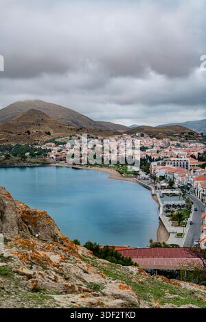 MYRINA, GRECIA - 22 OTTOBRE 2025: Vista panoramica dall'alto angolo della città costiera di Myrina e della baia sabbiosa vista dal castello in cima alla collina. Foto Stock