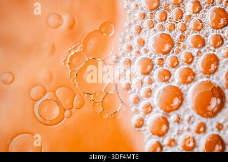 Foto macro di bolle di liquido organico in calde tonalità arancio e oro, per creare una splendida texture astratta con profondità e illuminazione soffusa. Foto Stock