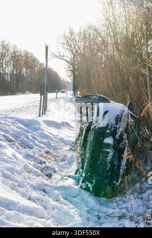 Un'auto in un fosso dopo la nevicata. Foto Stock