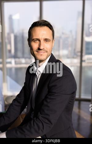 Bell'uomo di un'azienda latina che posa in un ufficio moderno Foto Stock