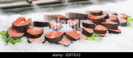 Filetto fresco di bistecche di salmone rosso su ghiaccio, raffreddato a vapore in una vetrina nel reparto pesce di un moderno supermercato da vicino. pesce nel Foto Stock