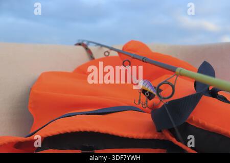 Il giubbotto di salvataggio arancione è necessario quando si catturano pesci predatori in mare Foto Stock