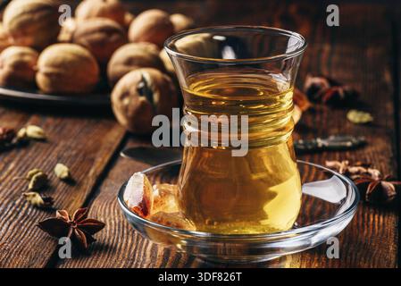 Il tè arabo con anice stellato, cardamomo e essiccato in calce vetro orientali su una superficie di legno Foto Stock