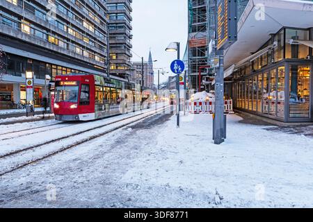 Un tram opera attraverso il centro innevato della città di Braunschweig in una mattina d'inverno. La neve copre le piste e i marciapiedi come trasporto pubblico Foto Stock