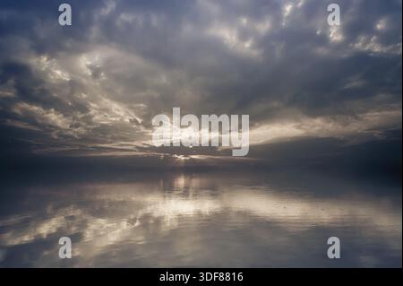 Incredibile paesaggio di sunrise. Calma acqua di lago con nuvole di riflessione Foto Stock