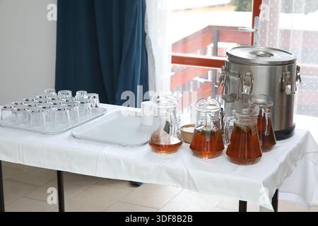 tè alle erbe in caraffe di vetro su una tovaglia bianca Foto Stock