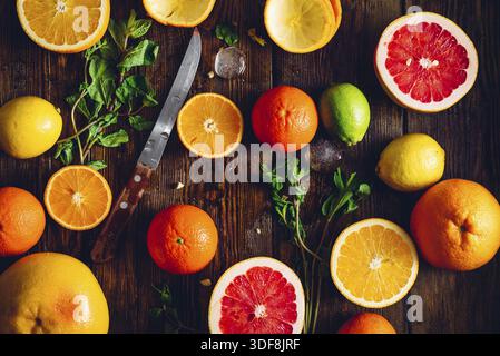 Sfondo con agrumi a fette, menta e coltello. Vista dall'alto Foto Stock