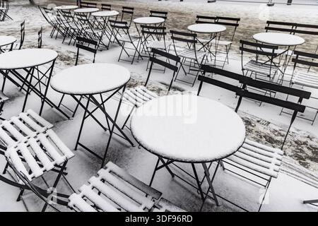 Inverno a Stoccarda. Sedie e tavoli da pranzo all'aperto sono coperti di neve. Strutture geometriche. Stoccarda, Baden-Wuerttemberg, Germania Foto Stock
