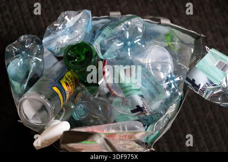 Raccolta dei rifiuti in un sacchetto presso un centro di riciclaggio nel pomeriggio Foto Stock