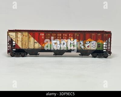 Modello in scala che rappresenta un'auto cargo con tramoggia del grano in stile statunitense, con cartelli in stile meteorologico e graffiti urbani, come si vede nelle configurazioni ferroviarie per hobby Foto Stock