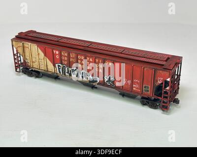 Modello in scala che rappresenta un'auto cargo con tramoggia del grano in stile statunitense, con cartelli in stile meteorologico e graffiti urbani, come si vede nelle configurazioni ferroviarie per hobby Foto Stock