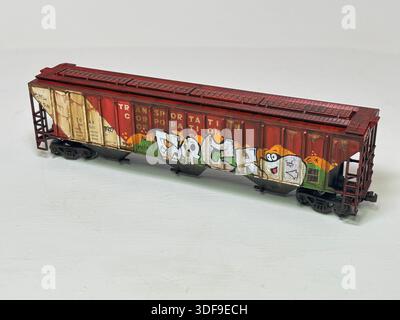 Modello in scala che rappresenta un'auto cargo con tramoggia del grano in stile statunitense, con cartelli in stile meteorologico e graffiti urbani, come si vede nelle configurazioni ferroviarie per hobby Foto Stock