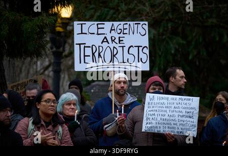 Un uomo ha in mano un cartello il 10 gennaio 2026, a Portland, Oregon, in una veglia a lume di candela per coloro che sono stati uccisi o feriti dagli agenti federali dell'immigrazione. Foto Stock