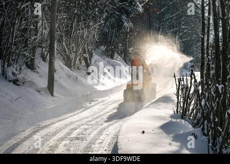 Deggendorf, Germania 11. 01. 2026: Im Bild: Ein Mann räumt mit einer Schneefräse eine stark verschneite Straße im Landkreis Deggendorf a Bayern. Der Winterdienst sorgt nach ergiebigem Schneefall für passierbare Verkehrswege nella regione der ländlichen Niederbayern. Bayern *** Deggendorf, Germania 11 01 2026 nella foto Un uomo usa una spazzaneve per sgombrare una strada pesantemente innevata nel distretto di Deggendorf in Baviera il servizio di sgombero stradale invernale garantisce strade percorribili nella regione rurale della bassa Baviera dopo forti nevicate Copyright: XFotostandx/xBreux Foto Stock