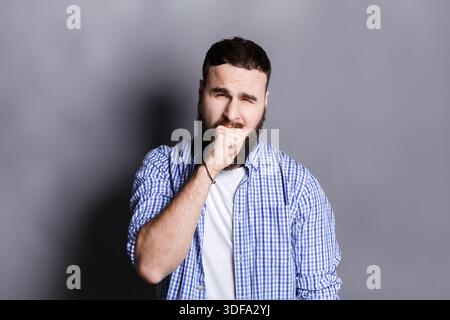 Ritratto di un uomo barbuto sbadigliante Foto Stock