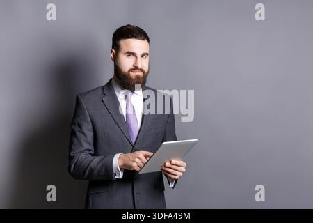 Giovane uomo d'affari con la barba che usa un tablet Foto Stock