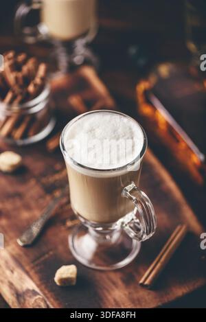 Irish coffee nel bicchiere su una superficie di legno Foto Stock