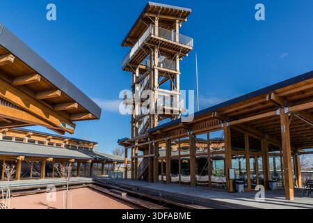 Una torre di osservazione in legno si erge sopra gli edifici del centro visitatori dello scavo di Çatalhöyük vicino a Küçükköy, in Turchia. La sua piattaforma superiore offre una vista panoramica su Çatalhöyük, uno degli insediamenti neolitici più famosi al mondo, e la pianura circostante di Konya. Foto Stock