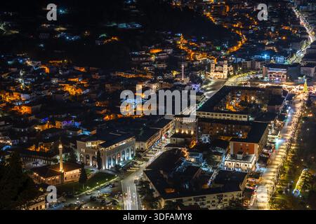 Paesaggio urbano notturno con edifici residenziali, strade illuminate del centro, chiese e moschee storiche, vista dall'alto, Berat, Albania Foto Stock