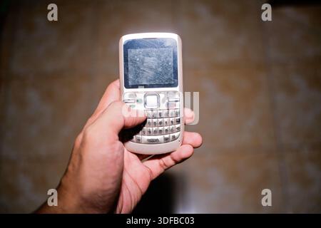 primo piano della mano che tiene il vecchio cellulare Foto Stock