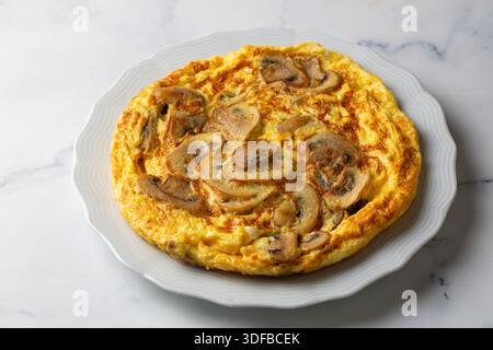 La frittata è un tipo di omelette italiana. Omelette di funghi in una padella di ghisa. Foto Stock