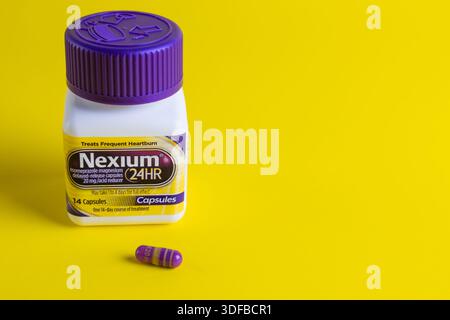Nexium la pillola viola 24 ore 20 mg capsule di riduttore acido su sfondo giallo Foto Stock