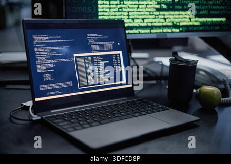 Primo piano del notebook che visualizza il codice di programmazione in Modern Office Setting Foto Stock