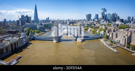 Vista aerea diurna panoramica del Tower Bridge aperto e dello skyline della città di Londra, Inghilterra Foto Stock