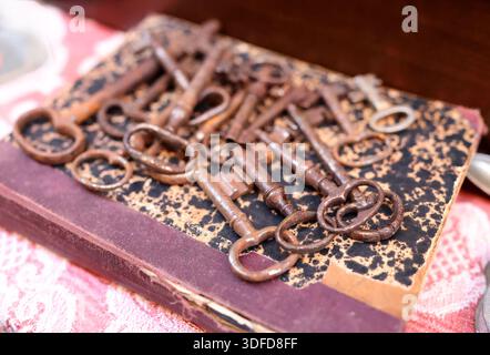 Mercato delle pulci antico in Europa, Italia. Articoli vintage. Una serie di chiavi di ferro arrugginite su un libro in città. Elementi retrò per la decorazione dello sfondo. Foto Stock