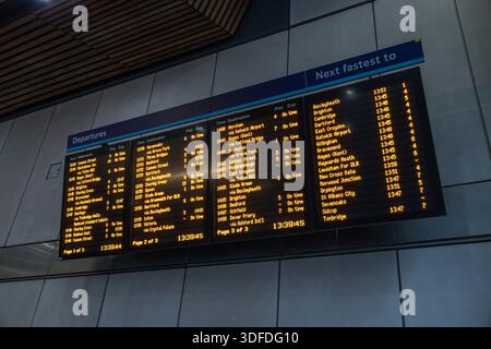 Partenza digitale del treno presso la stazione ferroviaria moderna Foto Stock
