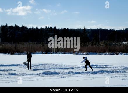 Il 4 gennaio 2026 ad Aitrang, in Germania, le persone camminano attraverso il lago ghiacciato ricoperto di neve e ghiacciato sotto un cielo azzurro, a causa del rischio di ghiaccio e delle condizioni pericolose. Fotografo: Immagini ddp/immagini a stella Foto Stock