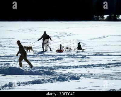 Il 4 gennaio 2026 ad Aitrang, in Germania, le persone camminano attraverso il lago ghiacciato ricoperto di neve e ghiacciato sotto un cielo azzurro, a causa del rischio di ghiaccio e delle condizioni pericolose. Foto Stock