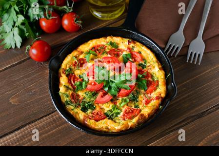 Frittata con pomodori e spinaci in padella Foto Stock
