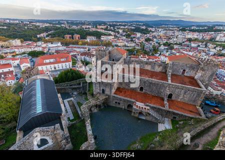 Leiria. Un'ampia vista aerea da un cortile del castello rivela le sue antiche mura in pietra e i tetti in terracotta, che si affaccia su un vibrante paesaggio urbano di Red-ti Foto Stock