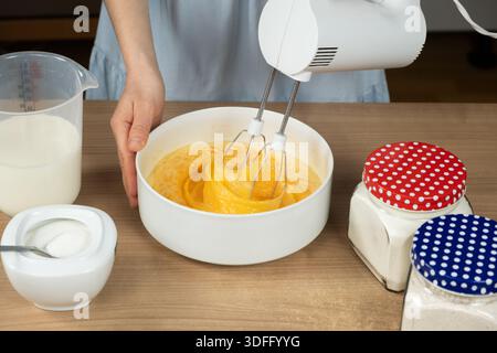 Primo piano del processo di cottura. Preparazione dell'impasto con un mixer su un piano cottura Foto Stock