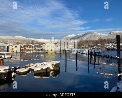 Case galleggianti al Mosquito Creek Marina con montagne innevate sullo sfondo. Vancouver settentrionale, Columbia Britannica, Canada Foto Stock