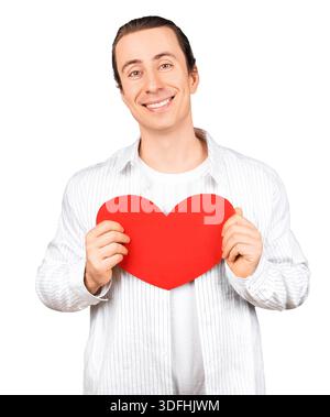 Bell'uomo sorridente che tiene un cuore rosso vicino al petto. Ritratto di un ragazzo felice e romantico per San Valentino, isolato su sfondo bianco. Ciao Foto Stock