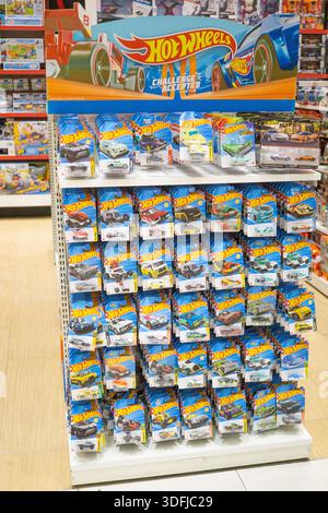 Macchinine giocattolo in metallo pressofuso Hot Wheels esposte in un grande stand all'interno di un negozio di giocattoli, che mostra il famoso marchio di auto in miniatura e i modelli da collezione. Foto Stock