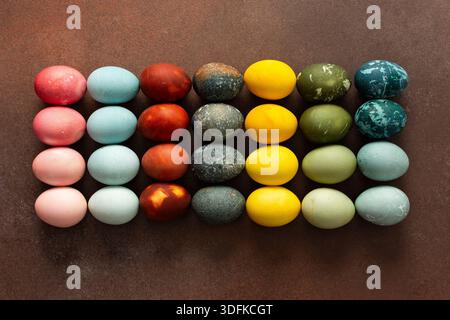 Le uova di Pasqua dai colori vivaci sono disposte in una griglia, con tonalità di rosa, blu, verde e giallo. Queste uova simboleggiano il rinnovamento e sono spesso parte di riunioni festive. Foto Stock