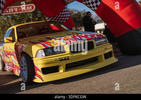 Imola, italia 01 gennaio 2026: bmw e36 coupé gialla, personalizzata per gli sport motoristici con decalcomanie audaci e ruote ad alte prestazioni in un evento di gara Foto Stock