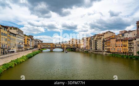 Vista di Ponte Vecchio a Firenze (Ponte Vecchio, Firenze) e degli edifici vicini lungo il fiume Arno in una luminosa giornata estiva, catturando lo storico castello Foto Stock