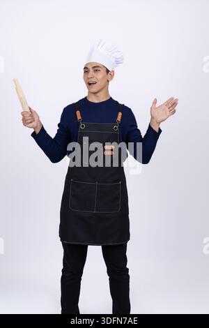 Cuoco in grembiule nero con utensili da cucina Foto Stock