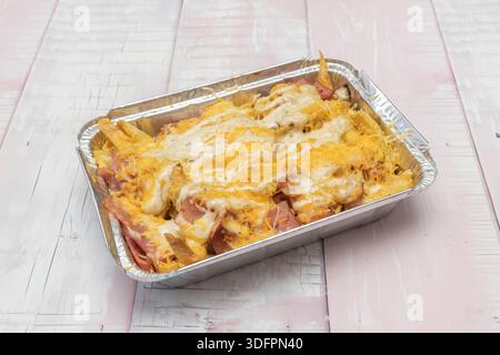 Un contorno che occupa il centro della scena, dove le patate fatte in casa, con il loro interno soffice e l'esterno tostato, sono inondate di un torrente di fusione Foto Stock
