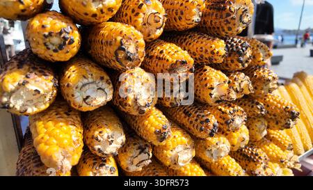 Mais grigliato su bastoncini in vendita al mercato locale Foto Stock