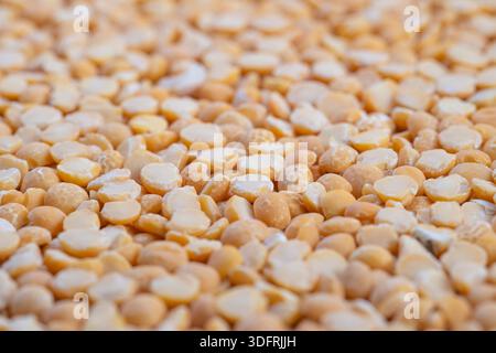 Messa a fuoco superficiale su piselli divisi, morbidi riflessi bokeh, forme circolari ripetute, accoglienti tonalità dorate, motivo culinario astratto, fotografia di scorta f Foto Stock