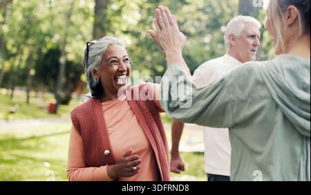 Istruttore, cinque persone anziane nel parco con esercizio fisico, classe e natura per supporto o aiuto. Pensionamento, hobby e personal trainer maturo Foto Stock