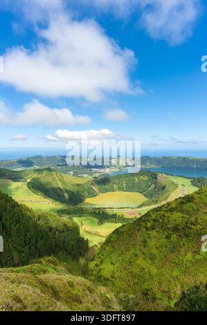 Vista panoramica delle isole Azzorre con rigogliose colline verdi e laghi blu sotto un cielo nuvoloso Foto Stock