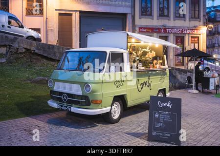 Porto, Portogallo - 26 novembre 2017: La vista di un camion del caffè Combi illuminato si distingue per i toni tenui dell'edificio dei servizi turistici. Foto Stock